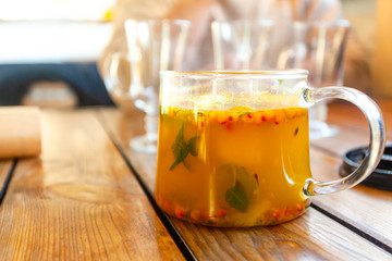glass teapot with orange sea buckthorn fruit tea