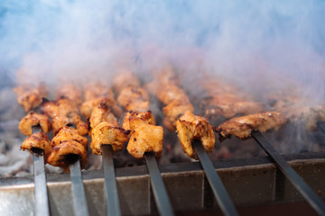 Chicken shish Kebab or kebap meat on metal skewer barbecue and embers in the Turkish restaurant. Skewering bbq Chicken Kebab..