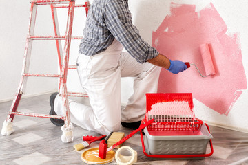 Professional house painter at work painting the wall © francescomou