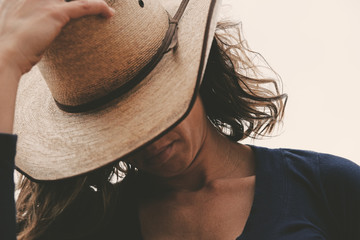 Western wear shows cowgirl in cowboy hat closeup for portrait of woman.