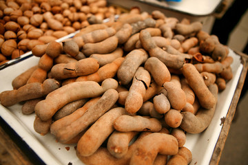 Unpeeled tamarind lie on the counter close-up. 
