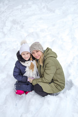 Fototapeta premium Family mother and child girl on winter walk in nature