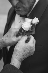 A grooms corsage buttonhole adjustment from his mum moments before his wedding