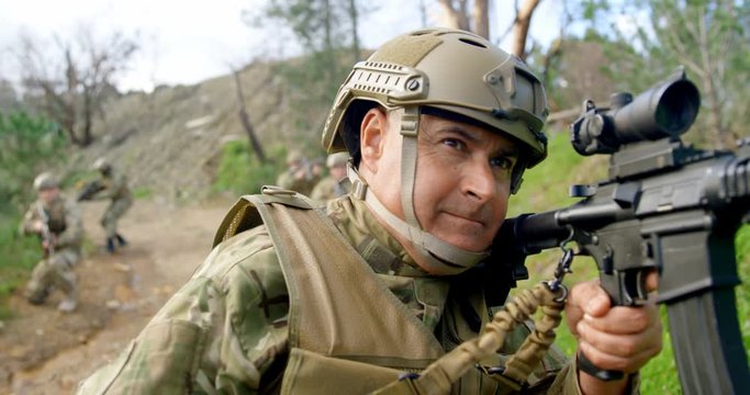Front view of mid-adult caucasian military soldier showing hand signal on field during training 4k