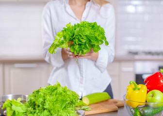 Fresh salad in the hands of the cook. Cooking healthy food with greens