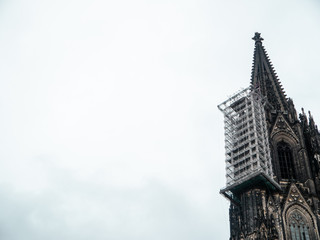 Fototapeta na wymiar Cologne Cathedral with scaffold against cloudy sky