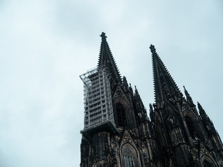 Cologne Cathedral with scaffold against cloudy sky