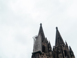 Fototapeta na wymiar Cologne Cathedral with scaffold against cloudy sky