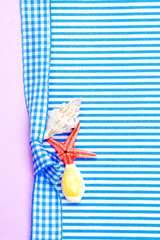 holiday gift card with blue bow and ribbon in the middle of decoration with  sea shells on blue and violet background