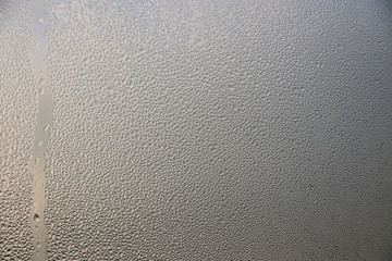 Stream drops on window glass with sunlight abstract on glass background