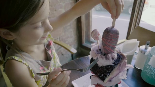 Top view of a positive little girl sitting at a table