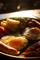 fried eggs, sausages and vegetable with sunlight in the morning , american breakfast