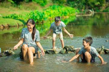 Obraz premium Family travelling at waterfall in the forest happy together