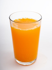 Glass of orange juice on white
