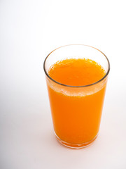 Glass of orange juice on white