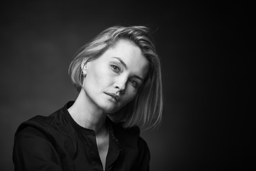 Dramatic black and white portrait of a beautiful woman on a dark background