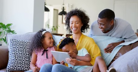Front view of black family using digital tablet in living room at home 4k - Powered by Adobe
