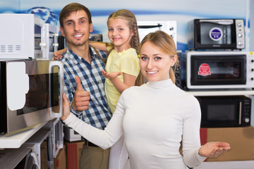 Smiling couple with kid  in hypermarket