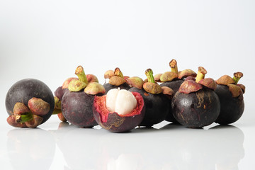 Mangosteen, an exotic asian fruit isolated on white with reflection.