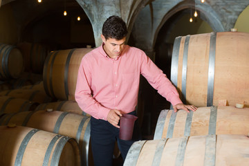 interested man posing in winery cellar