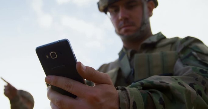 Low angle view of military soldier using mobile phone during training 4k