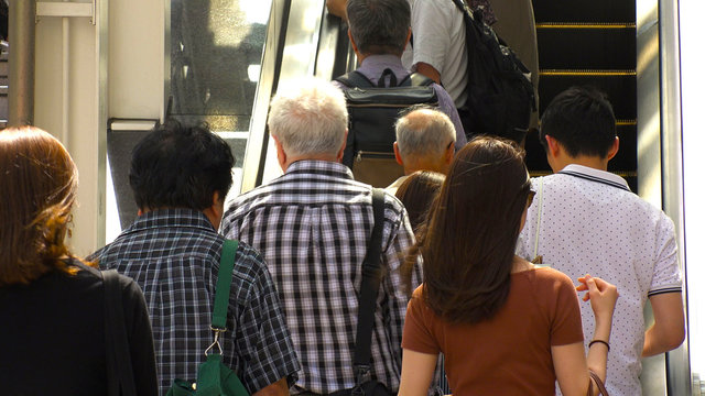 SHINJUKU,  TOKYO,  JAPAN - CIRCA MAY 2018 : BACK SHOT of PEOPLE using ESCALATOR near Shinjuku train station.