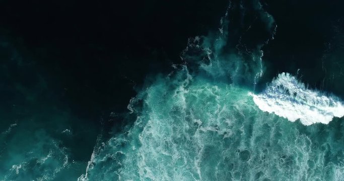 Top down aerial view of giant ocean waves crashing and foaming