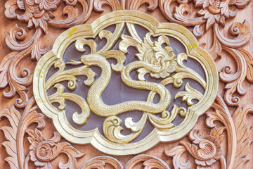 Traditional Thai style wood carving Snake of 12 Zodiac,on the wall of temple in Thailand