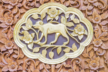 Traditional Thai style wood carving monkey of 12 Zodiac,on the wall of temple in Thailand