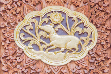 Traditional Thai style wood carving rat of 12 Zodiac,on the wall of temple in Thailand