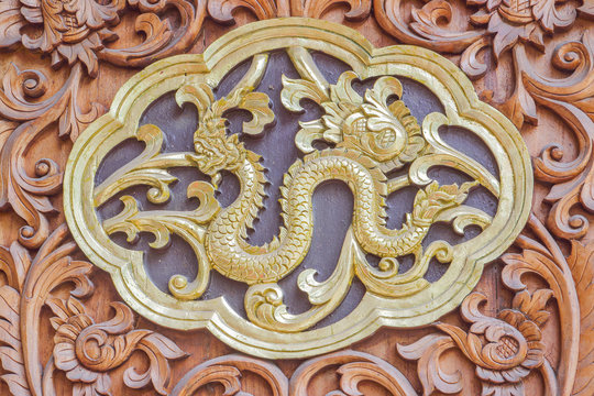 Traditional Thai style wood carving serpent of 12 Zodiac,on the wall of temple in Thailand