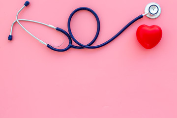 Heart health, health care concept. Stethoscope near rubber heart on pink background top view space for text