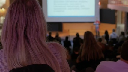 female CEO or speaker tells something during business event or conference