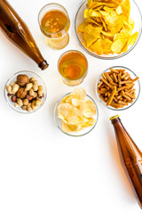 Snacks and beer. Chips, nuts, rusks near beer on white background top view space for text