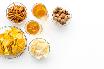 Snacks and beer. Chips, nuts, rusks near beer on white background top view space for text