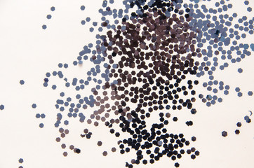 black sparkles scattered on the background, the texture of glitter
