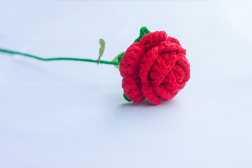 Crochet red roses with yarn for giving to those we love, Valentine's day isolated on white paper background.