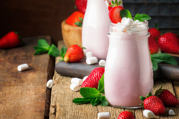 Strawberry smoothies and cocktails with fresh berry and green mint, decorated marshmallows, summer drink, wood old background, selective focus