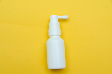 white bottle spray on a yellow background, spray from the cold