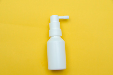 white bottle spray on a yellow background, spray from the cold