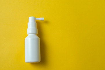 white bottle spray on a yellow background, spray from the cold