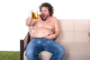 Funny fat man drinking beer at home. 