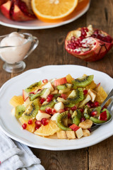 Salad with various fresh fruits on a white plate   