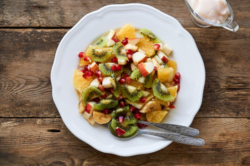 Salad with various fresh fruits on a white plate   