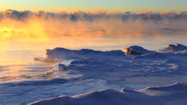 Time lapse of steaming lake with icebergs at sunrise, subzero extreme cold.