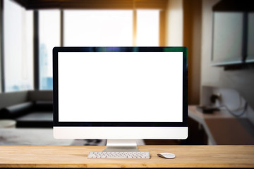 Fototapeta premium Workspace with computer Monitor, Keyboard, blank screen coffee cup smartphone, and tablet on a table or White Screen Isolated in bright office room interior.