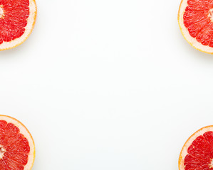 Frame of grapefruit halves on a white background. Minimal composition of healthy fruits. Copy...