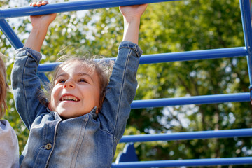 Obraz premium A girl climbs the stairs on the playground in the park