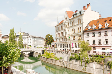 Fototapeta na wymiar Restaurants and cafes along Ljubljanica river with famous Triple bridge in the center of Ljubljana, Slovenia