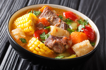Delicious Sancocho thick meat soup with vegetables close-up in a bowl. horizontal